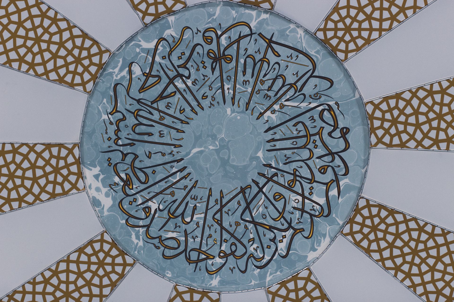 Intricate Islamic geometric and calligraphic patterning on a domed ceiling