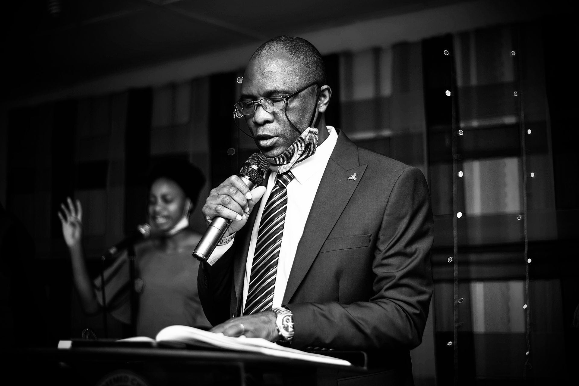 A Nigerian executive in formal dress speaking at a microphone